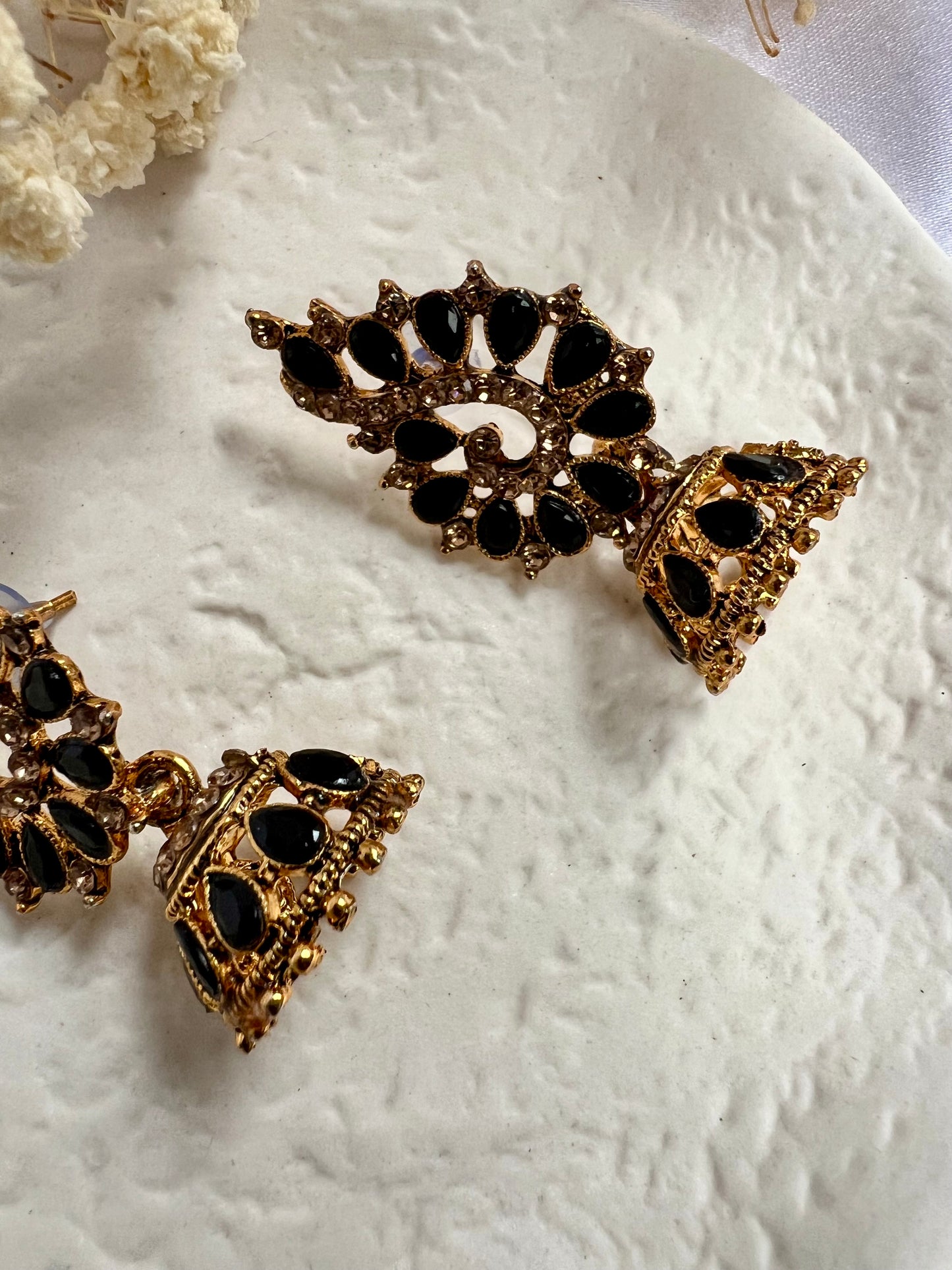 Golden jhumkas embellished with pearl shaped black stones E3058