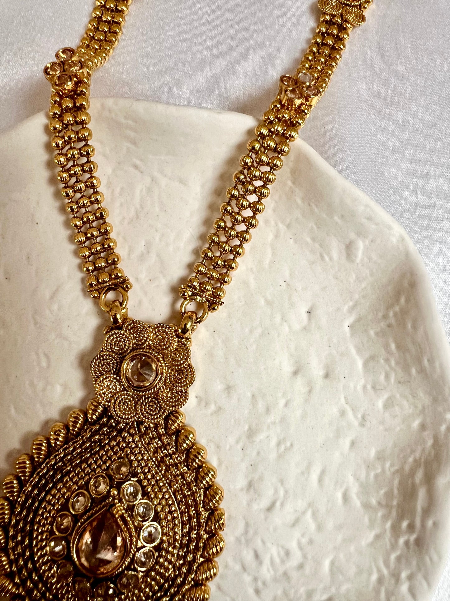 THARSHINI - long tear drop shaped pendant golden necklace with round stones N3212