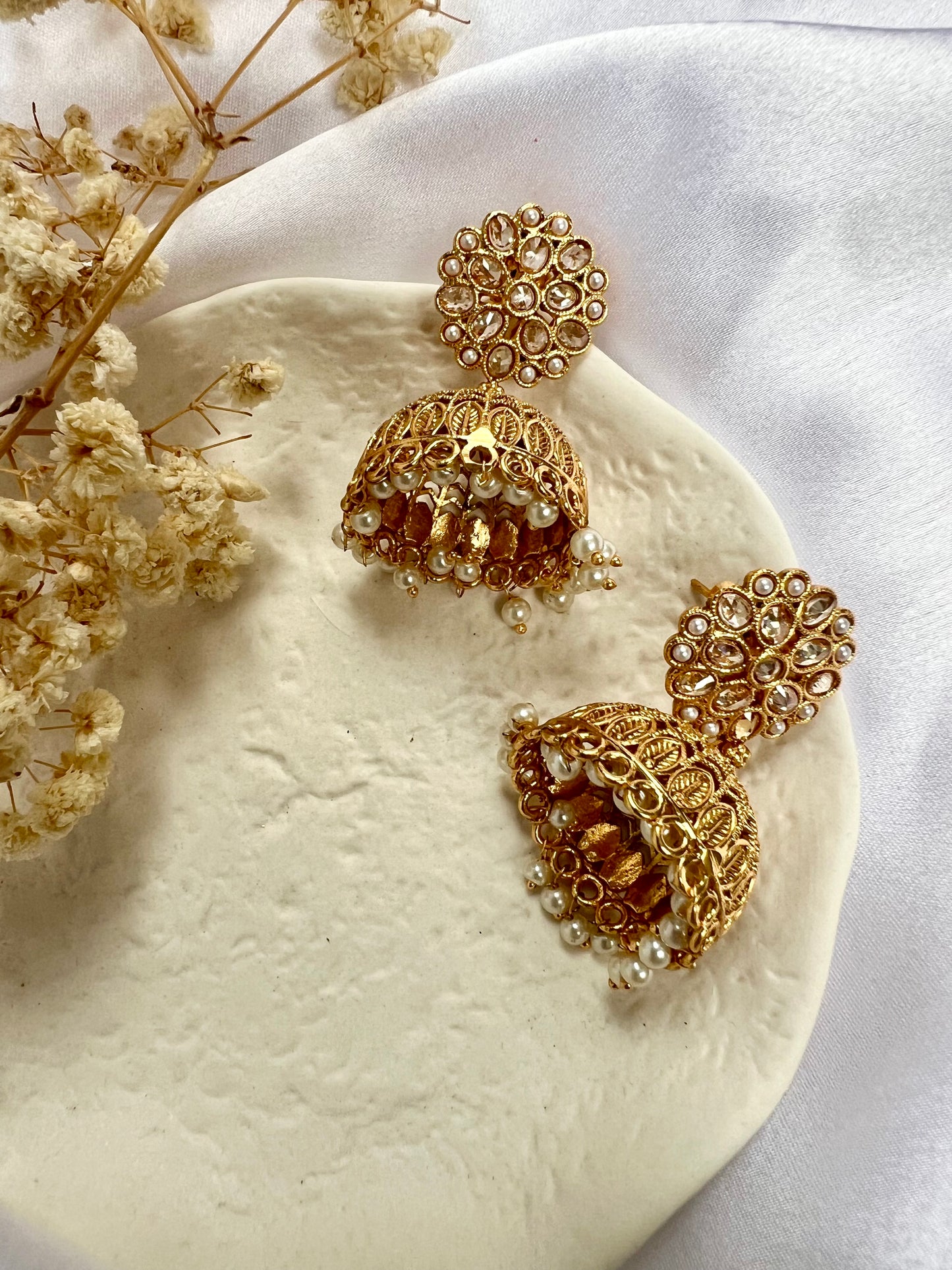 Golden jhumkas with pearls and clear stones E3034