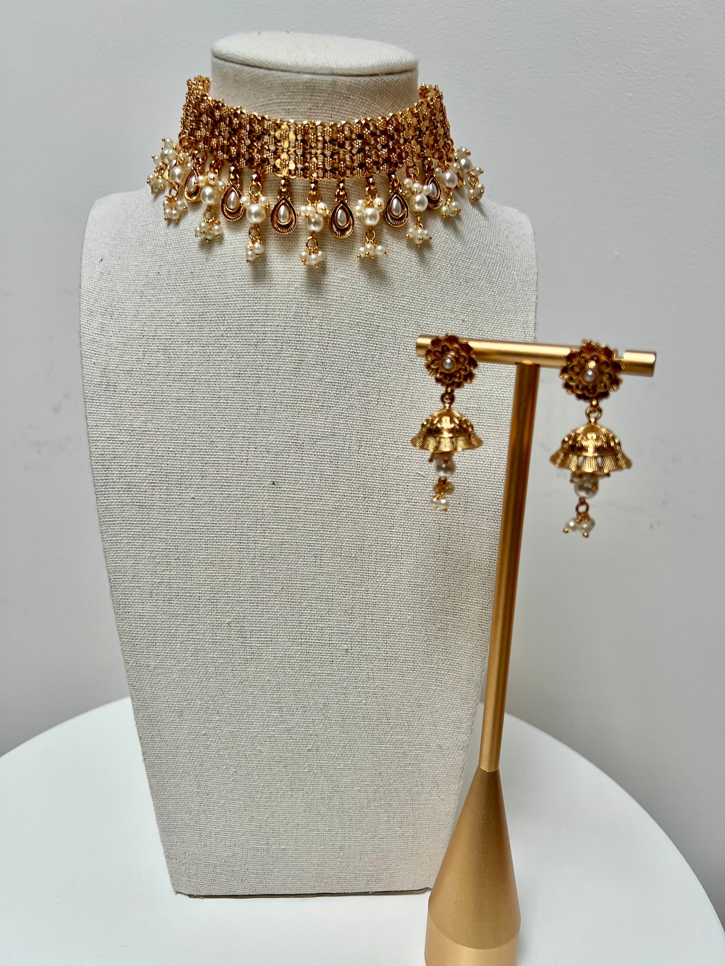 Golden high neck band necklace embellished with dangling pearls, comes with matching small jhumkas