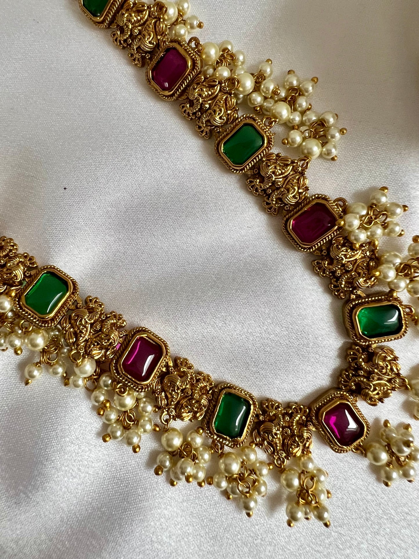 TASHA - Gold plated short necklace with rubygreen stones and dangling ivory pearls, matching jhumkas included N3046