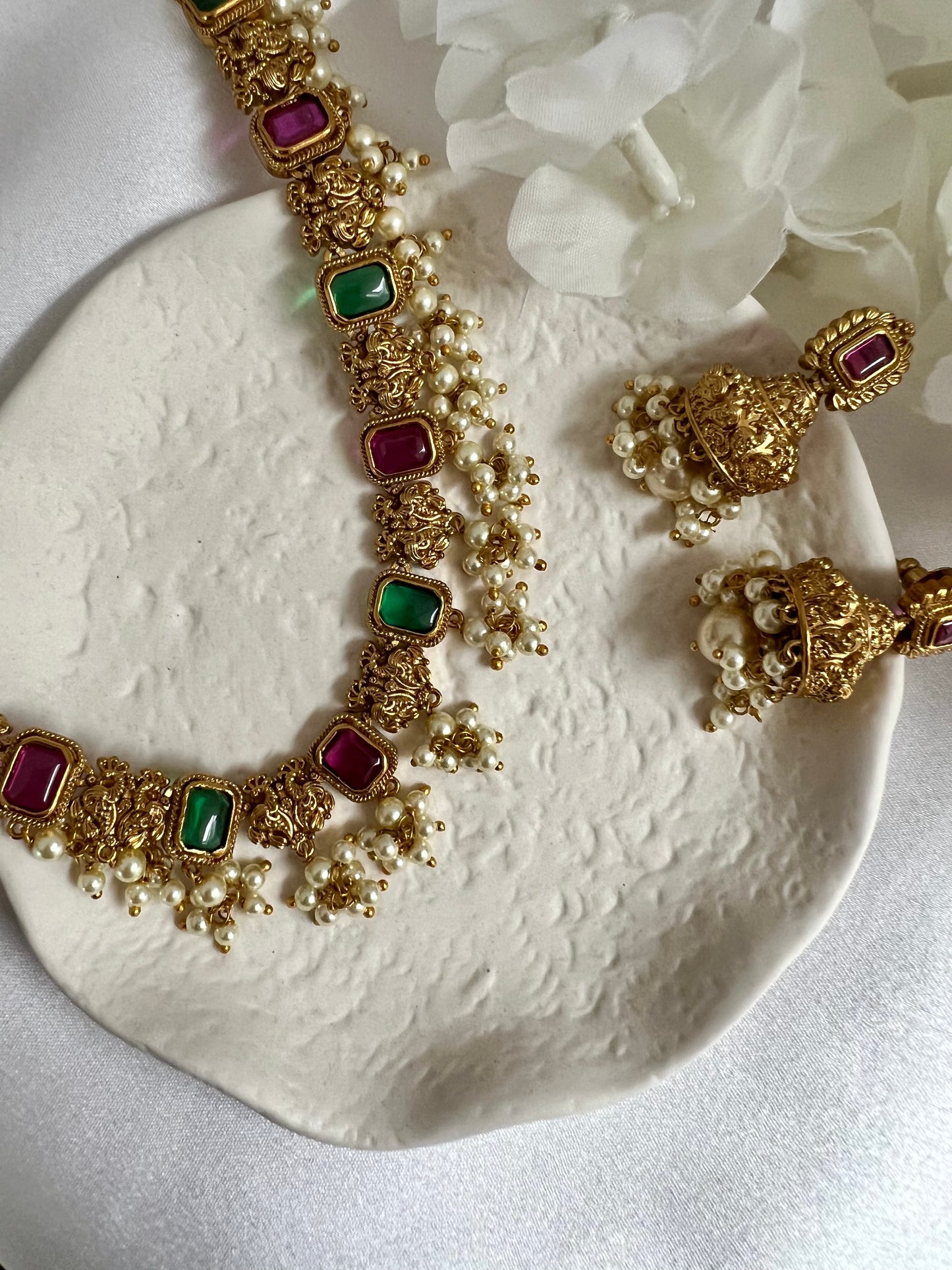 TASHA - Gold plated short necklace with rubygreen stones and dangling ivory pearls, matching jhumkas included N3046