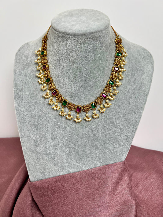 TASHA - Gold plated short necklace with rubygreen stones and dangling ivory pearls, matching jhumkas included N3046