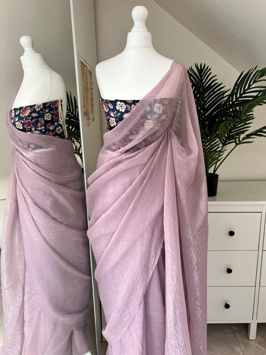 Pastel lavender crushed chiffon saree with a simple woven shine,includes a printed matching blue silk blouse