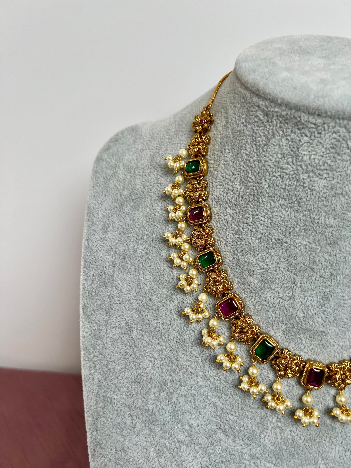 TASHA - Gold plated short necklace with rubygreen stones and dangling ivory pearls, matching jhumkas included N3046